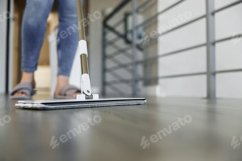 Preview: Woman mopping, wiping floor in modern home setting