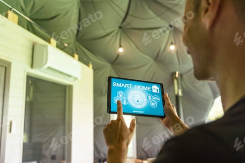 Preview: Man use application for smart home control on tablet. Interior of living room in the background.