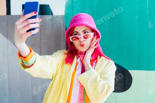 Preview: Excited pink hair woman taking a selfie photo outdoors. Emotional fashion woman taking selfie photo
