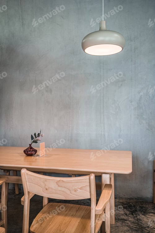 Preview: Wooden table and chair with lighting lamp and flower vase on cement wall