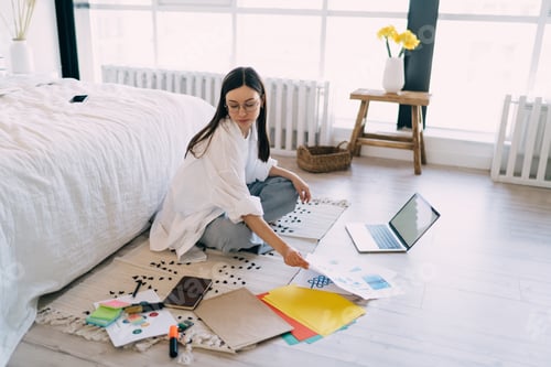 Preview: Busy female financier working remotely on laptop with documents