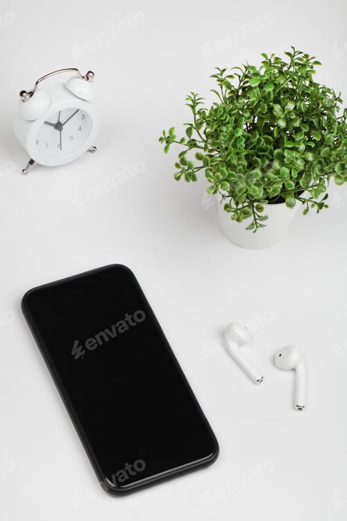 Preview: Working table with smart phone, flower, clock and headphone. Top view. flat lay copy space