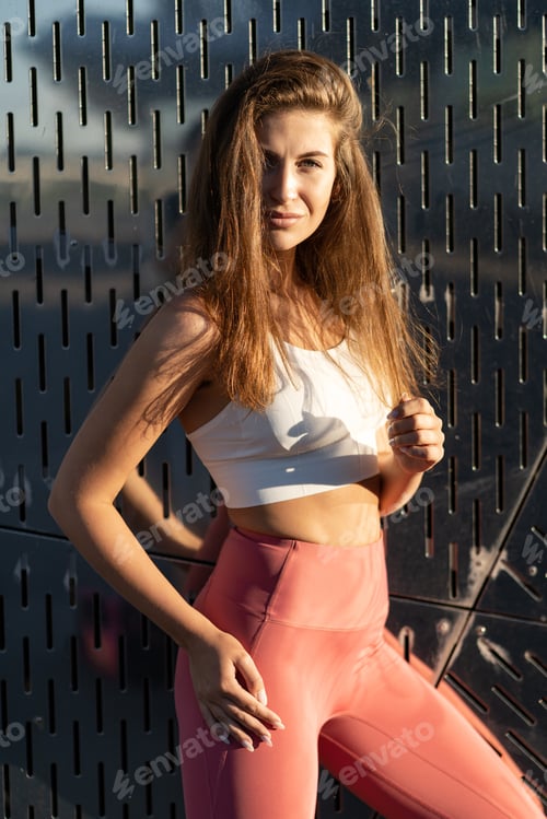 Preview: Woman in Activewear Leaning Against Modern Wall