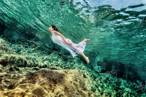 Preview: Woman swimming near rock
