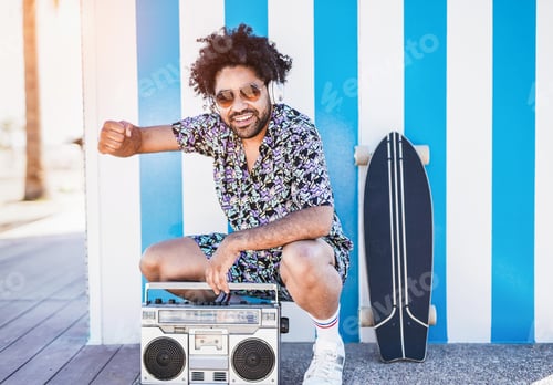 Preview: Trendy african man dancing on the beach to music from vintage boombox