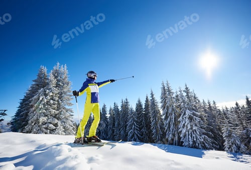 Preview: Happy woman posing on skis before skiing. Sunny day at ski resort.