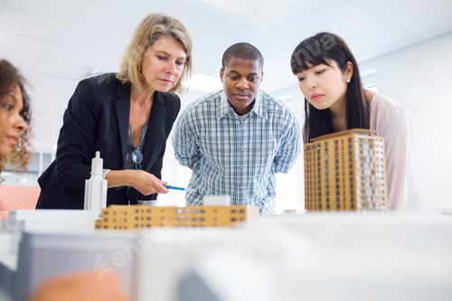 Preview: Team of architects reviewing model building plans.