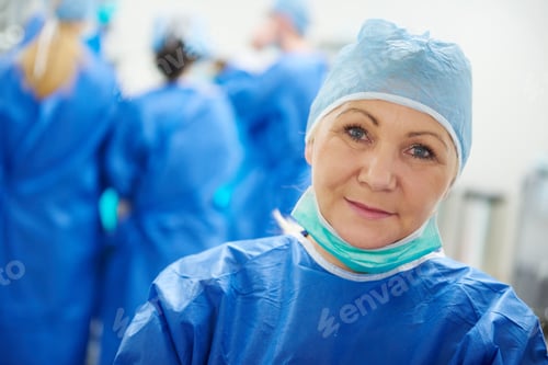 Preview: Mature female surgeon in surgical cap