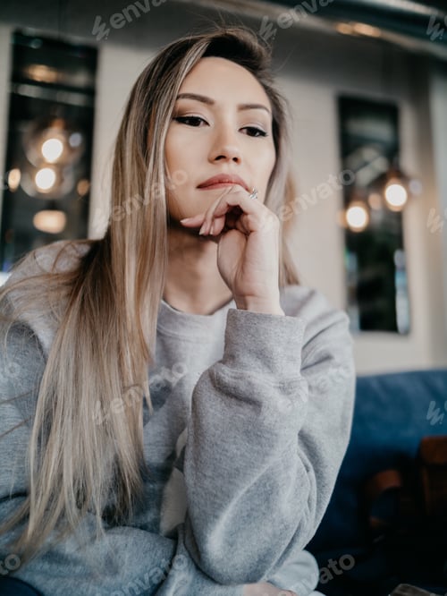 Preview: Young woman portrait millennial thinking wondering listening office work cafe restaurant hand chin