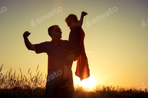 Preview: Father and son playing superhero at the sunset time.