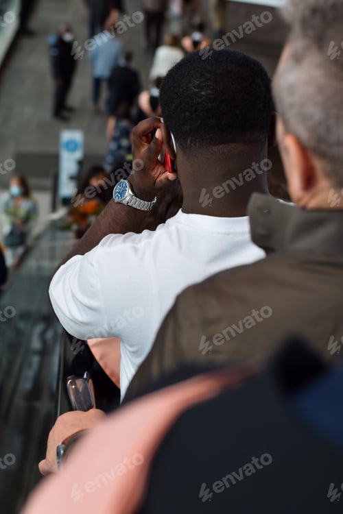 Preview: People going down escalator in busy shopping mall or subway