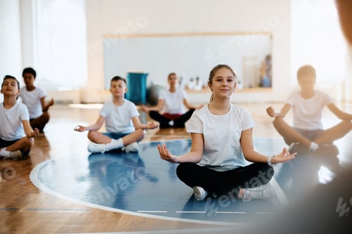 Preview: Group of elementary students practicing Yoga during PE class at school.