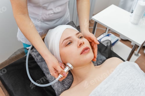 Preview: Woman in the beauty services. Masseur makes vacuum roller massage