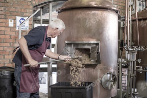 Preview: Brewer cleaning a copper kettle in the brewery
