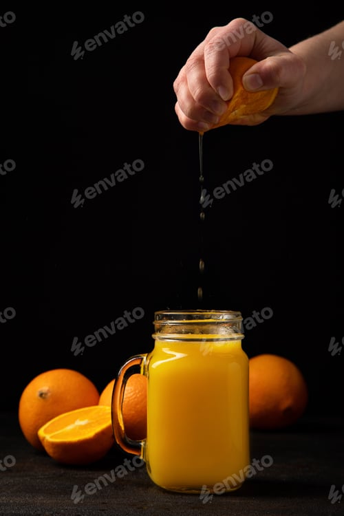 Preview: Hand squeezes orange juice into a glass