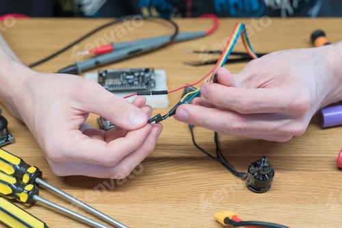 Preview: Technician engineer in workshop. Repairman is soldering circuit board of electronic device