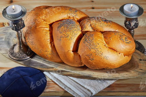 Preview: Shabbat challah on a wooden stand, with candles and a rustic bale. Shabbat Shalom