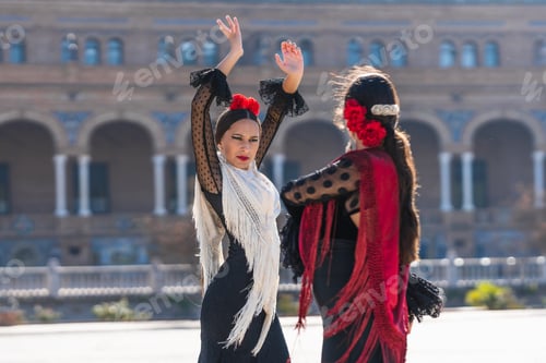 Preview: Two woman in flamenco dress dancing with passion outdoors