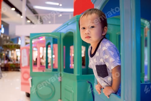 Preview: A little boy is having fun playing on the playground and in a train at the indoor.