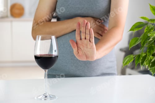 Preview: Pregnant woman show NO gesture to glass of wine.