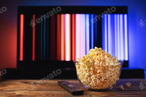 Preview: A glass bowl of popcorn and remote control in the background the TV works.