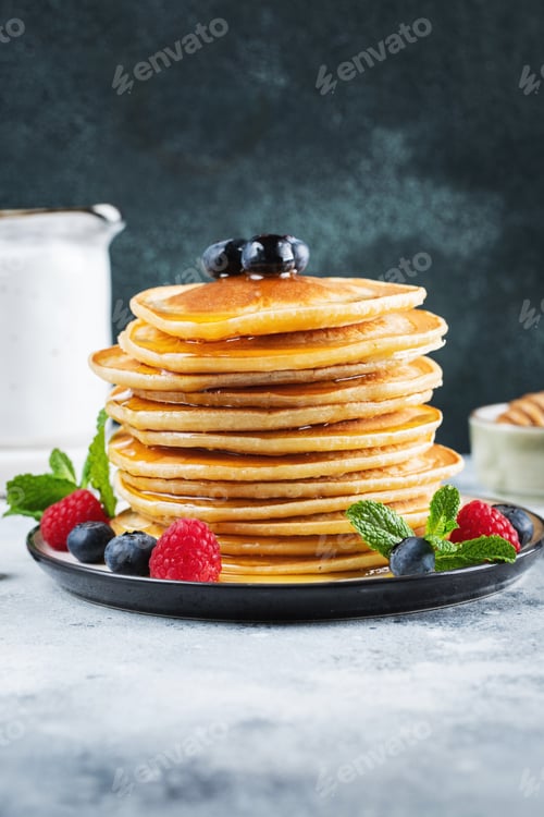 Preview: Delicious pancakes, with fresh blueberries, raspberry and maple syrup or honey on a dark background