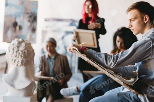 Preview: Young multiracial students drawing plaster bust in art school