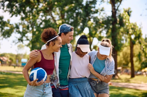 Preview: Young happy friends having fun playing volleyball in nature.