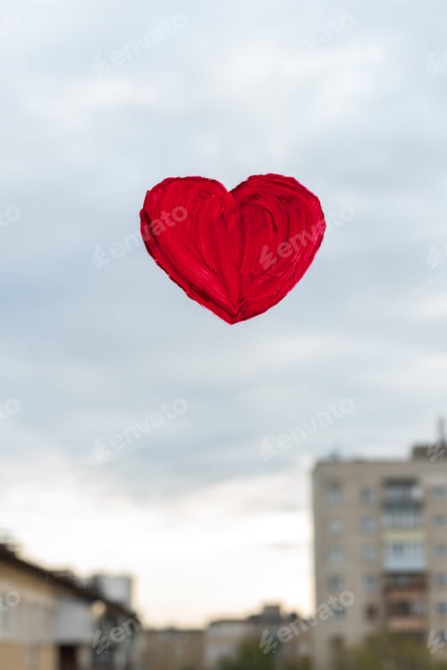 Preview: Red heart painted with paints on the glass of the window overlooking street. Valentine's day concept