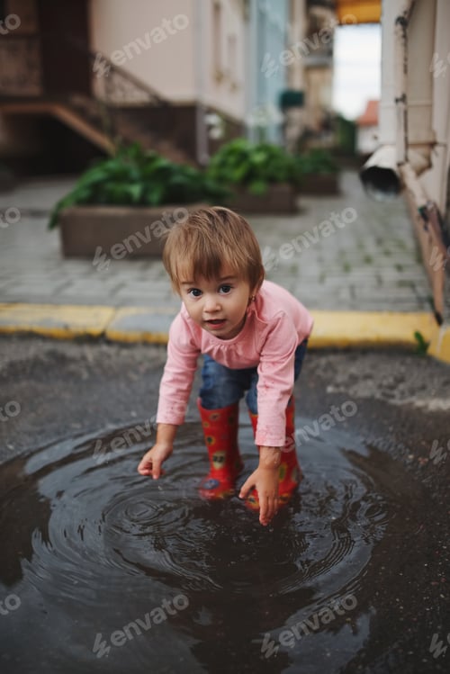 Preview: girl plays in the puddle outdoors