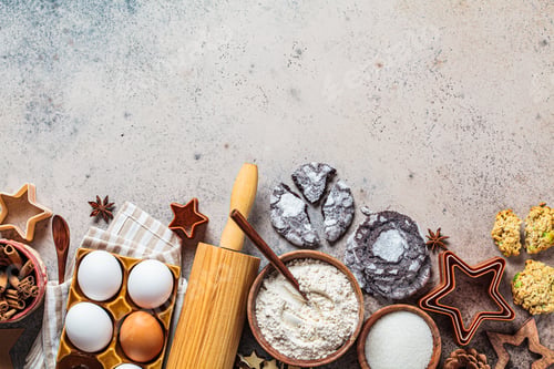 Preview: Christmas baking concept. Ingredients for Christmas cookies on a dark background, copy space.
