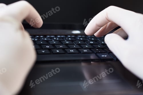 Preview: Hands in gloves typing on the laptop keyboard. Virus protection concept