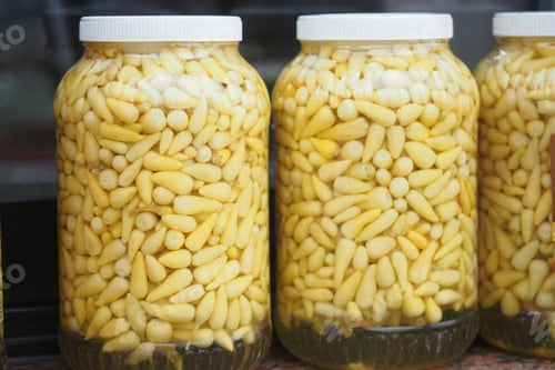 Preview: Beautifully arranged jars of vibrant and pickled yellow vegetables displayed attractively