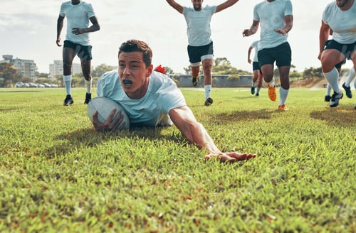 Preview: We play to win. Shot of a rugby player scoring a try while playing on a field.