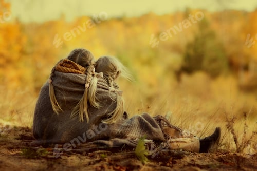 Preview: Two girls with pigtails, wrapped in a warm blanket, sit and gaze into the distance