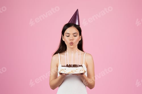 Visualização: Mulher soprando velas no bolo de aniversário