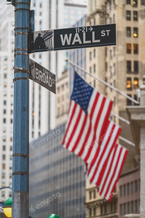 Preview: Wall Street "WALL ST" sign and broadway street over American national flags