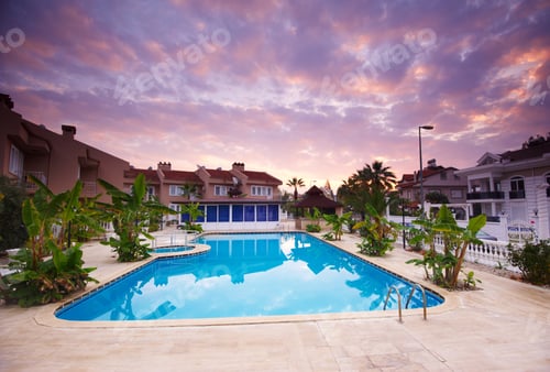 Preview: Swimming pool by the luxury resort hotel buildings