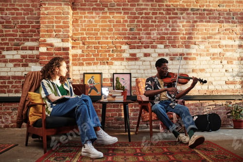 Preview: Young woman looking at her African American boyfriend playing violin