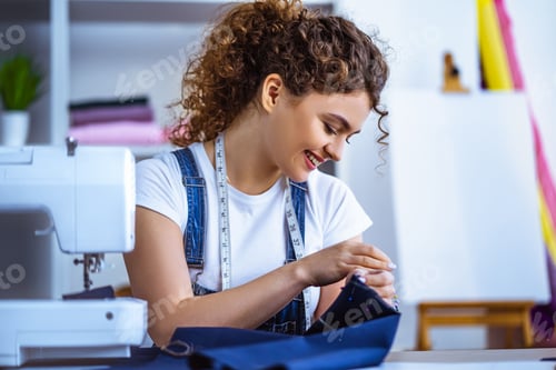 Preview: The happy tailor working near the sewing machine
