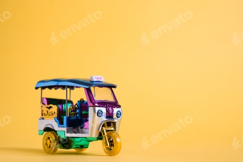 Preview: Model Toy tuk tuk isolated on yellow background. Thai traditional taxi in Bangkok Thailand. Souvenir