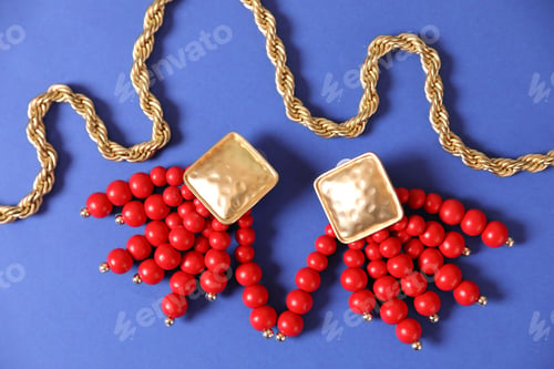 Preview: Beautiful gold jewelry on blue background, flat lay