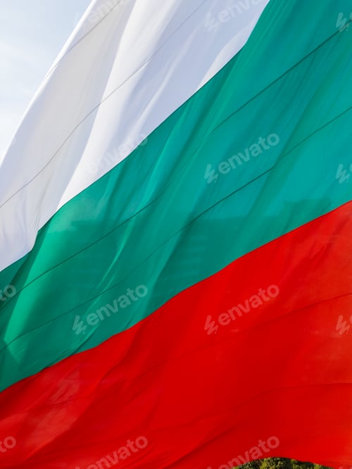 Preview: The Bulgarian flag waves proudly above a coastal city, with the vast sea and green landscape in the