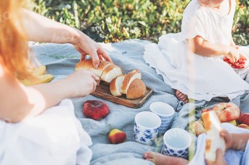 Preview: Young mother with children in white dresses on picnic at sunny summer day