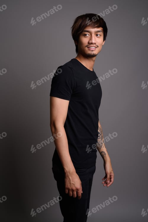 Preview: Young Asian man against gray background
