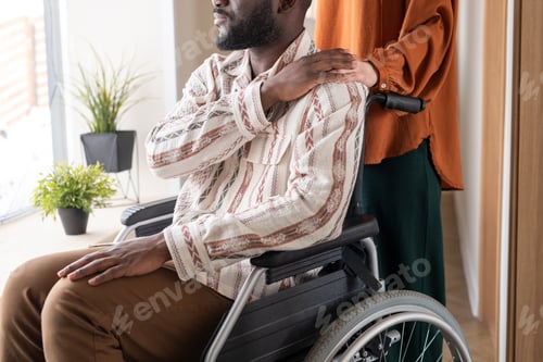 Preview: Side view of man with disability keeping his hand on that of female caregiver