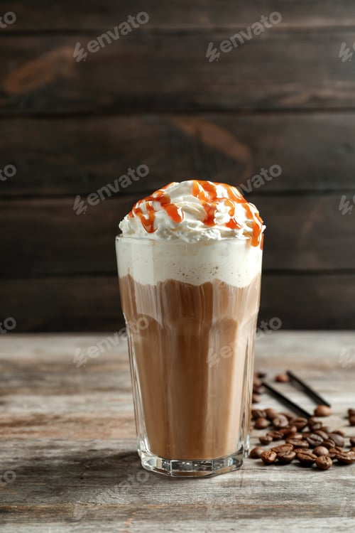 Preview: Glass of coffee with caramel topping on wooden table