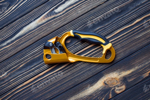 Preview: Top view. Isolated photo of climbing equipment. Part of carabiner lying on the wooden table