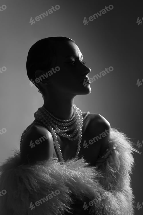 Preview: Beauty model stands in profile wearing multiple strands of pearls and a fur wrap