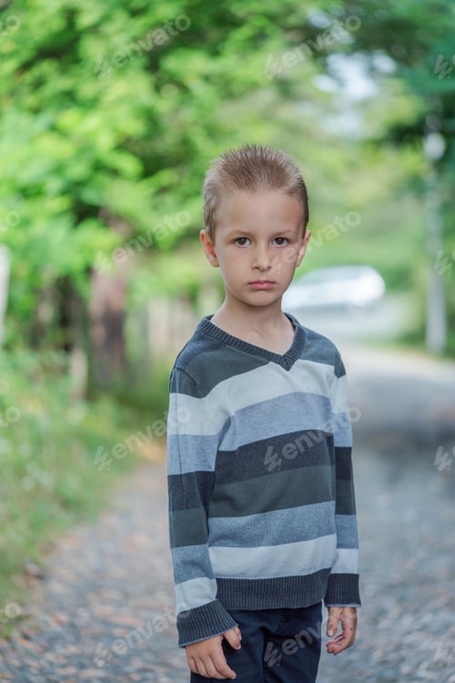 Preview: Little boy standing in rural nature. Inquisitive childhood